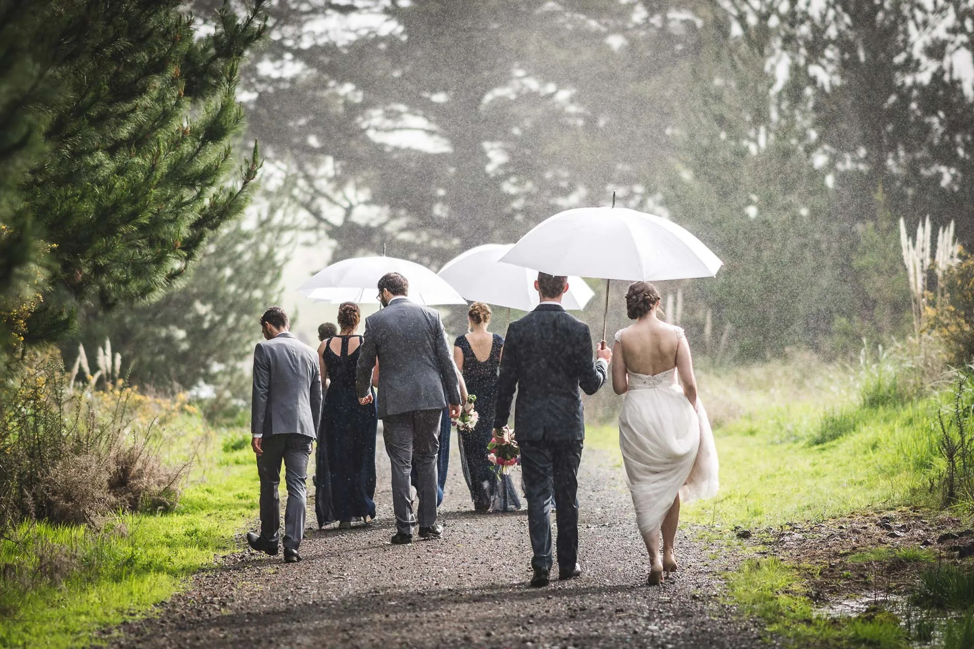Rainy wedding party with umbrellas