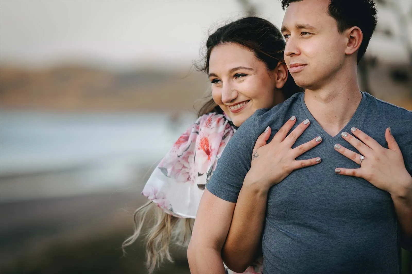 Affectionate couple posing beside the coast