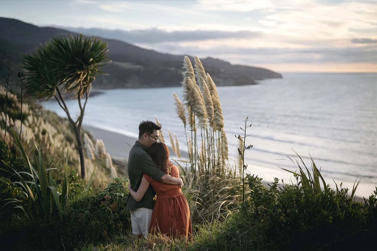 Couple embracing above the Raglan coast