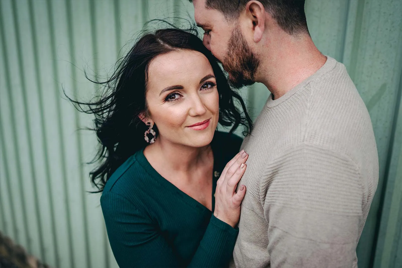 Relaxed couple portrait against a corrugated wall
