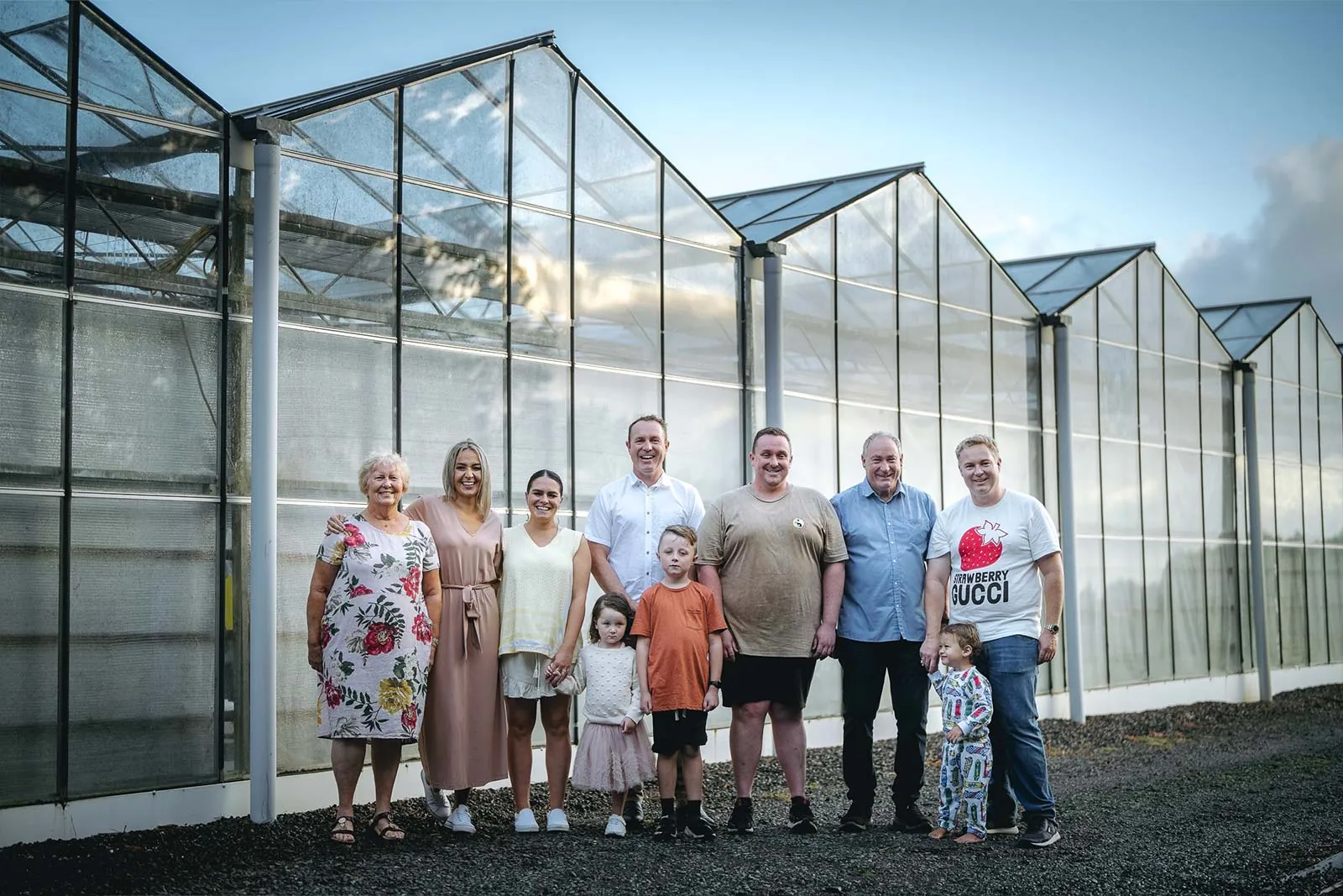 Extended family portrait beside a greenhouse