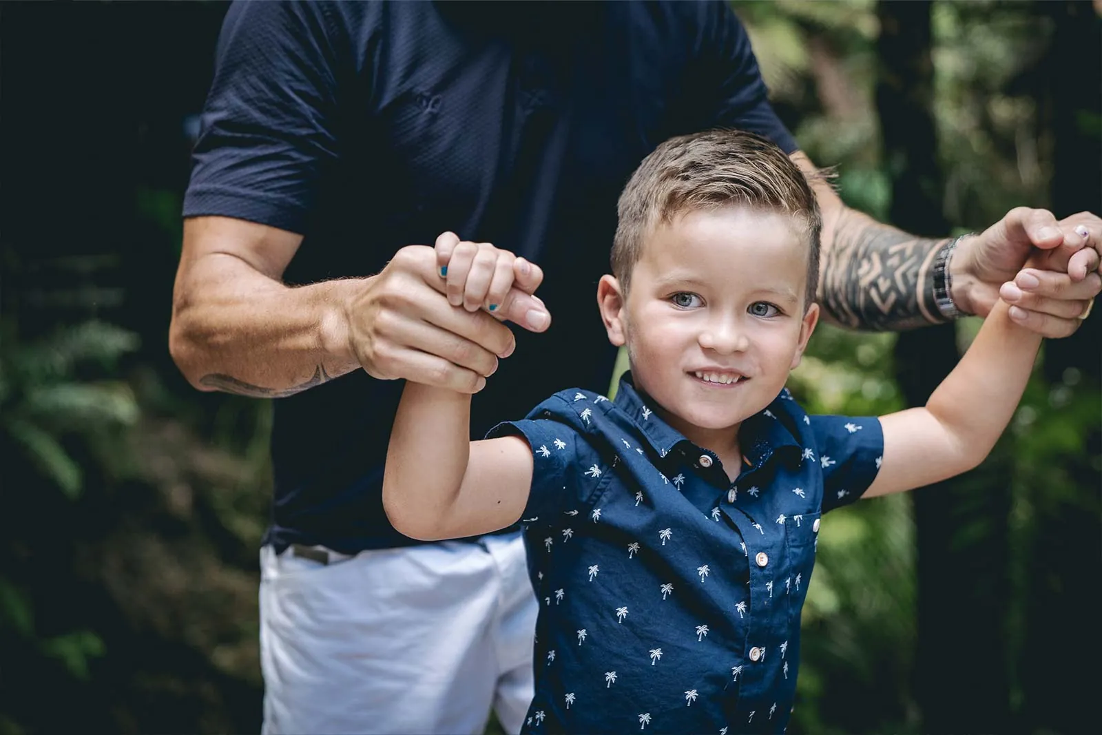 Young child walking while holding both parents