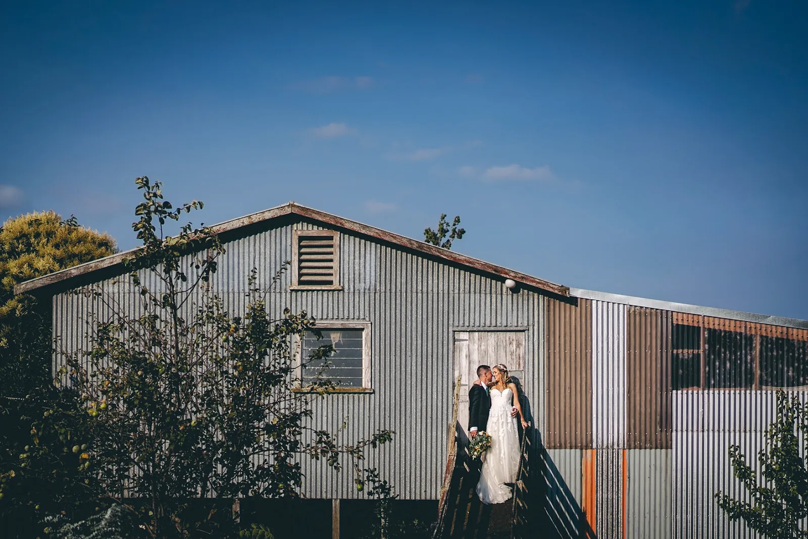 Bride and groom portrait outside a rustic barn