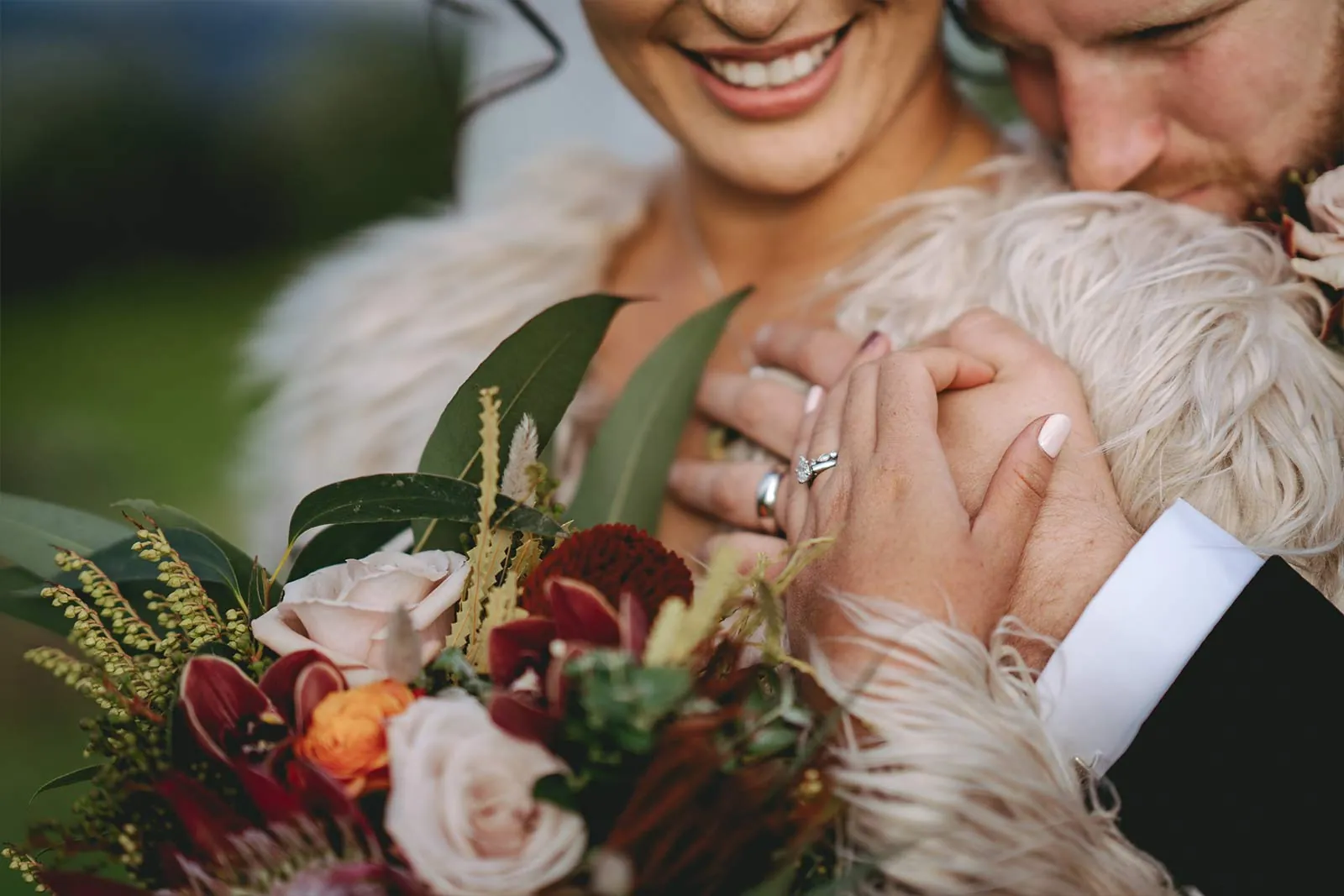 Wedding rings and bouquet during a close embrace